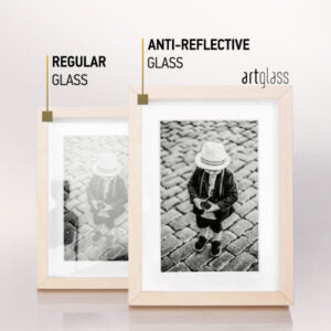 AR70 nect to standard glass, image shows side by side in a wood frame how art glass helps with reflections on the glass, regular glass is set back and has a persons reflction in glass, art glass does not