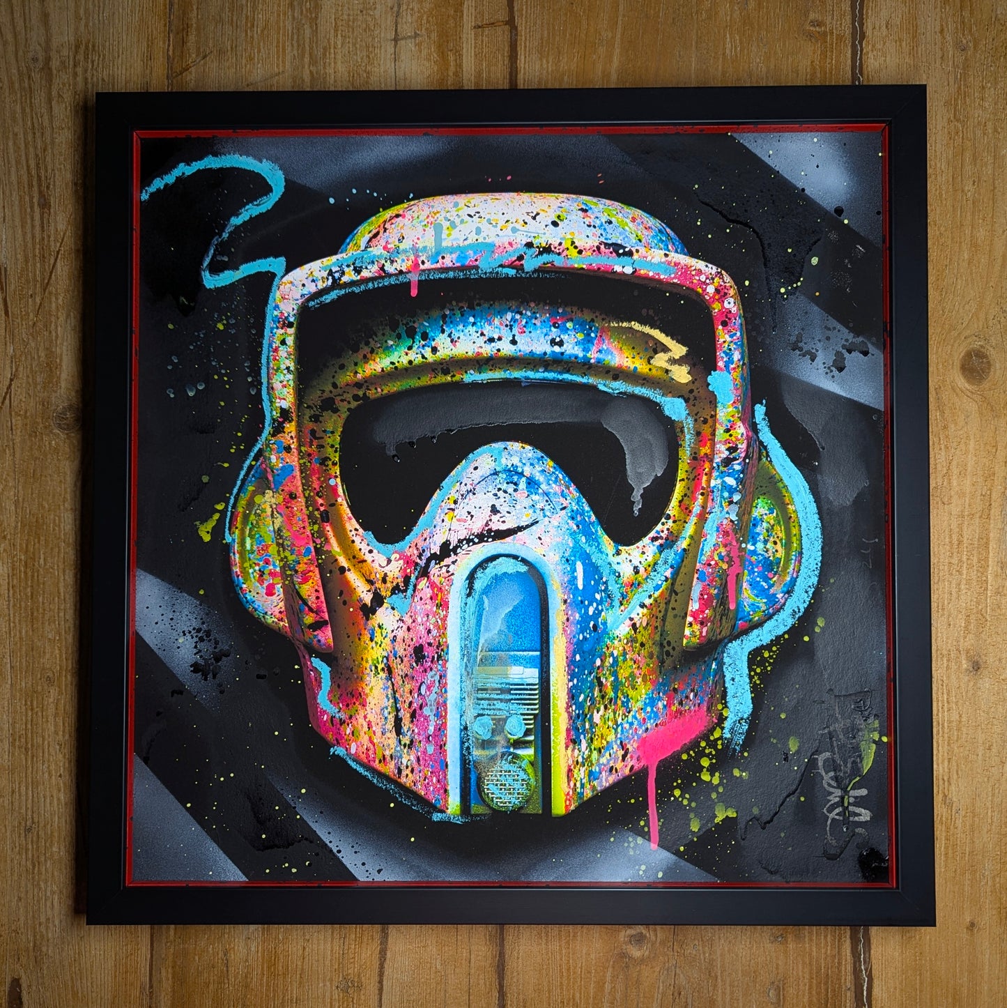 lp edits hand embellished print of a starwars style helmet, artwork is framed in a black frame with colourful painted slips