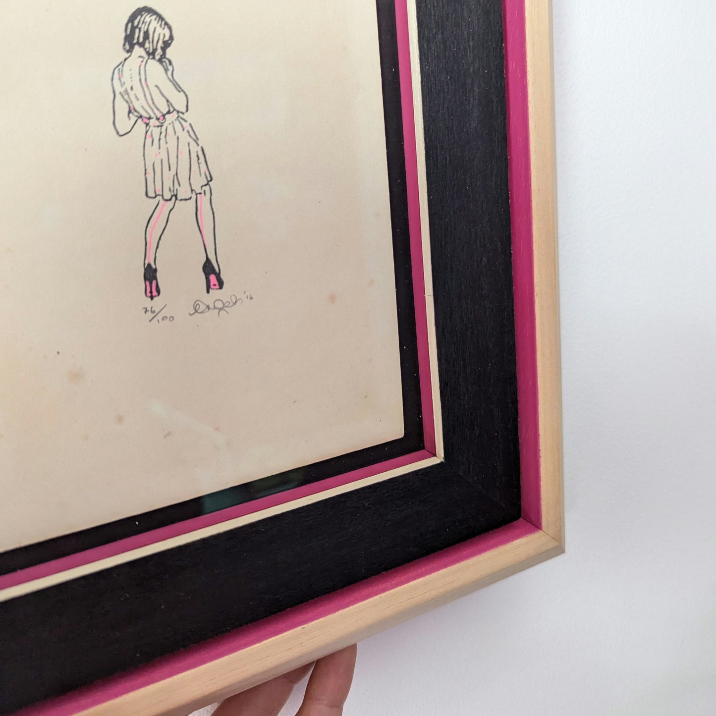 ceal warnants high fashion woman stood in summer dress and high heels, drawn in pencil style with pink details on old book paper, framed in bespoke natural wood with pink and black painted details