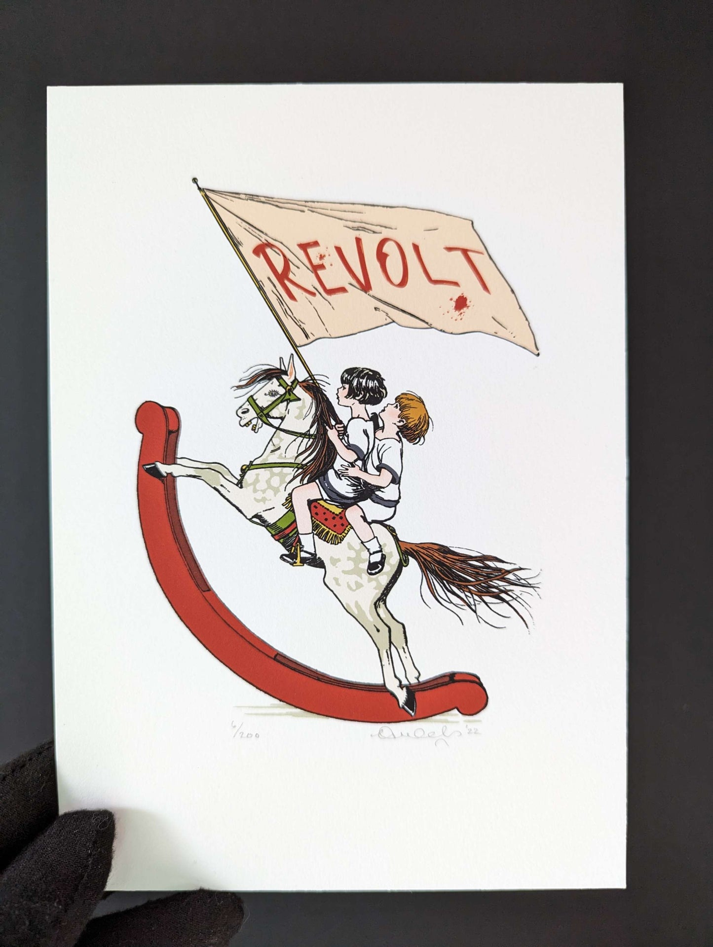 ceal warnants colourful artwork, two children riding a rocking horse aggressively holding a large flag with word revolt on it. artwork is being held by someone wearing a black glove.