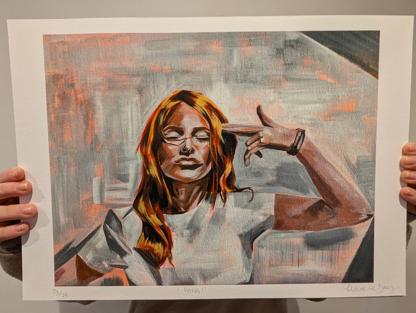 Artistic depiction of a woman with gun hand held to her head, white boarder. artwork being held by person against white wall