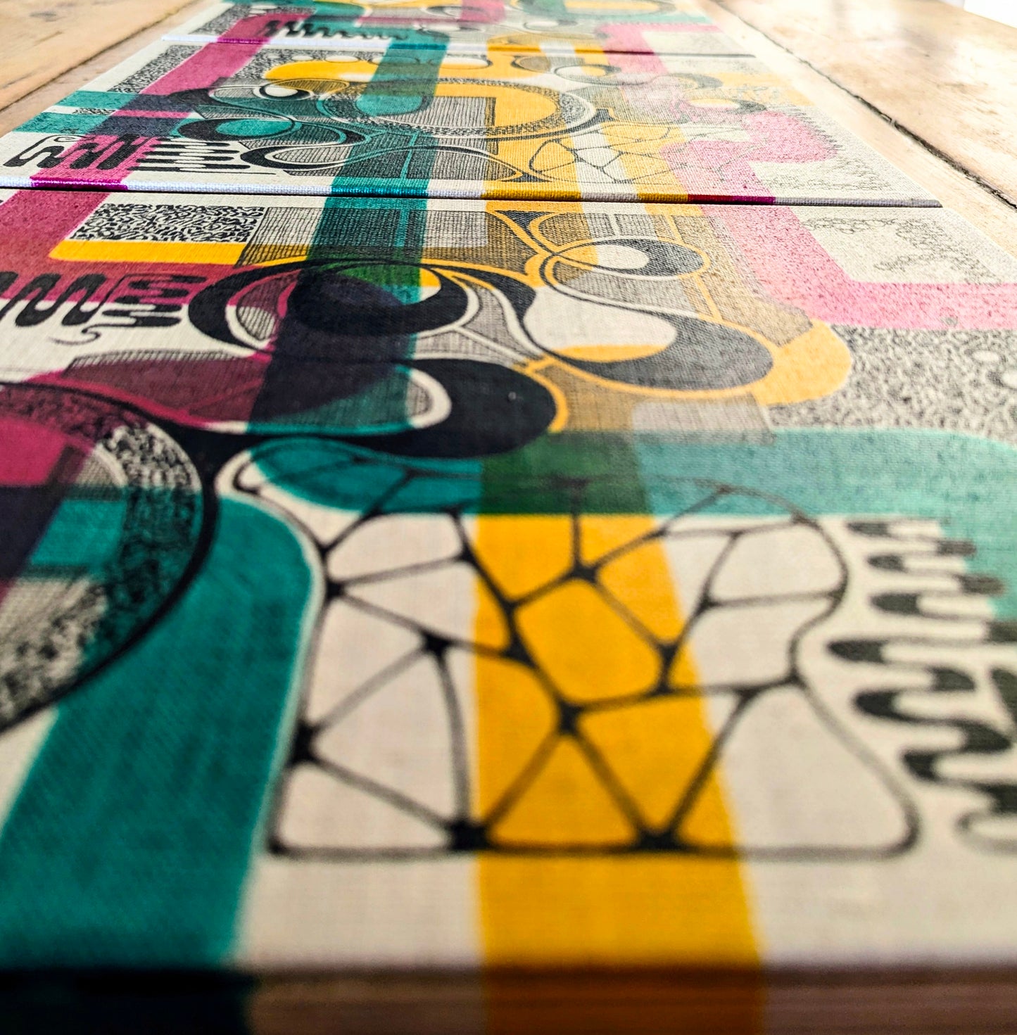 close up of colourful green, red and yellow with black doodles on off white boards
