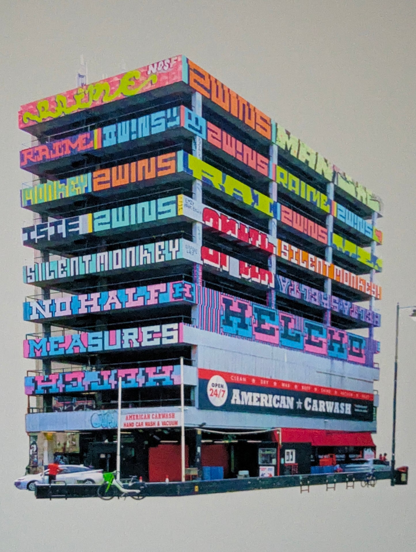 Colorful graffiti building facade with text and branding on a gray background