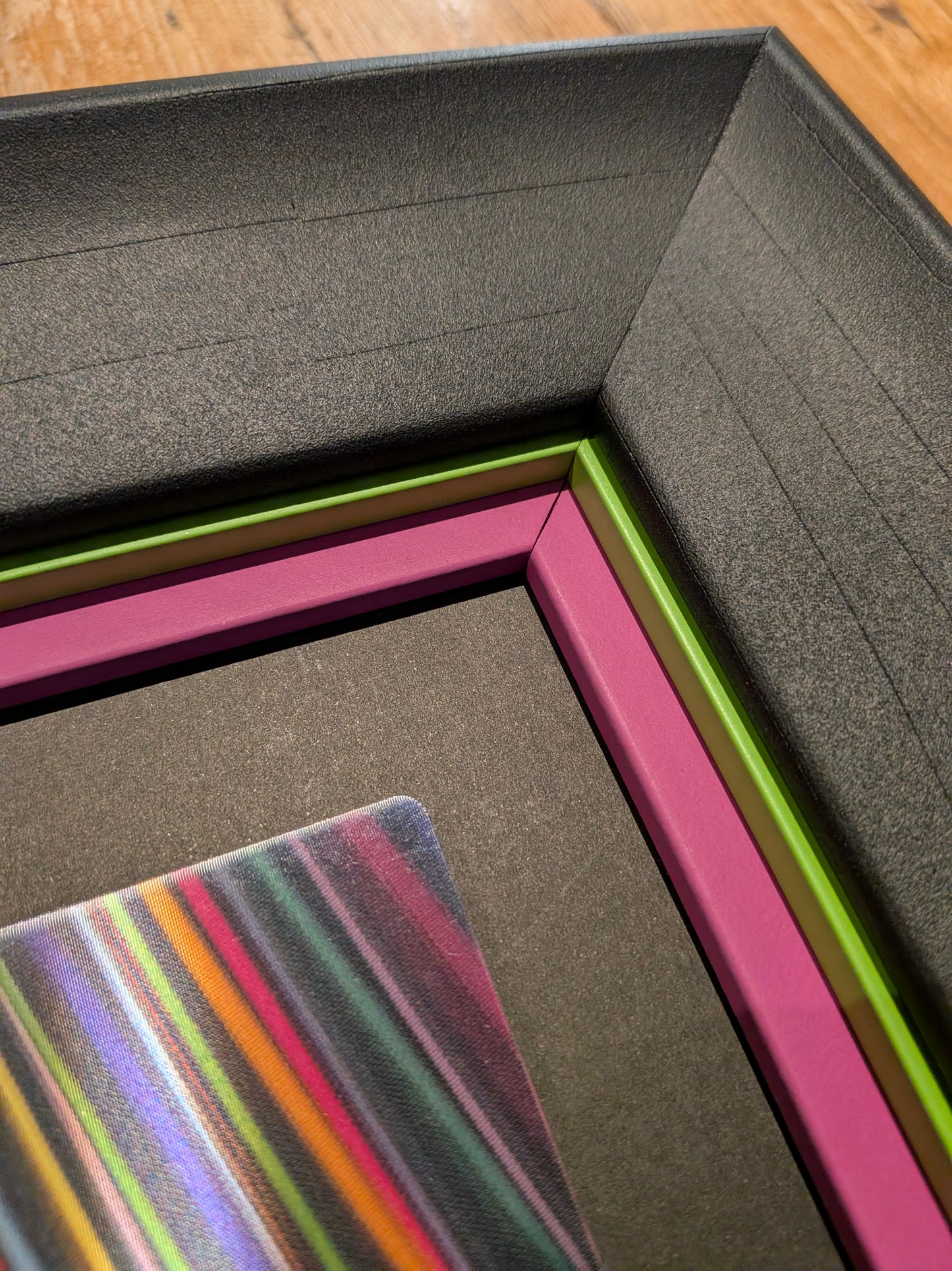 Colorful striped card inside a black box on a wooden surface