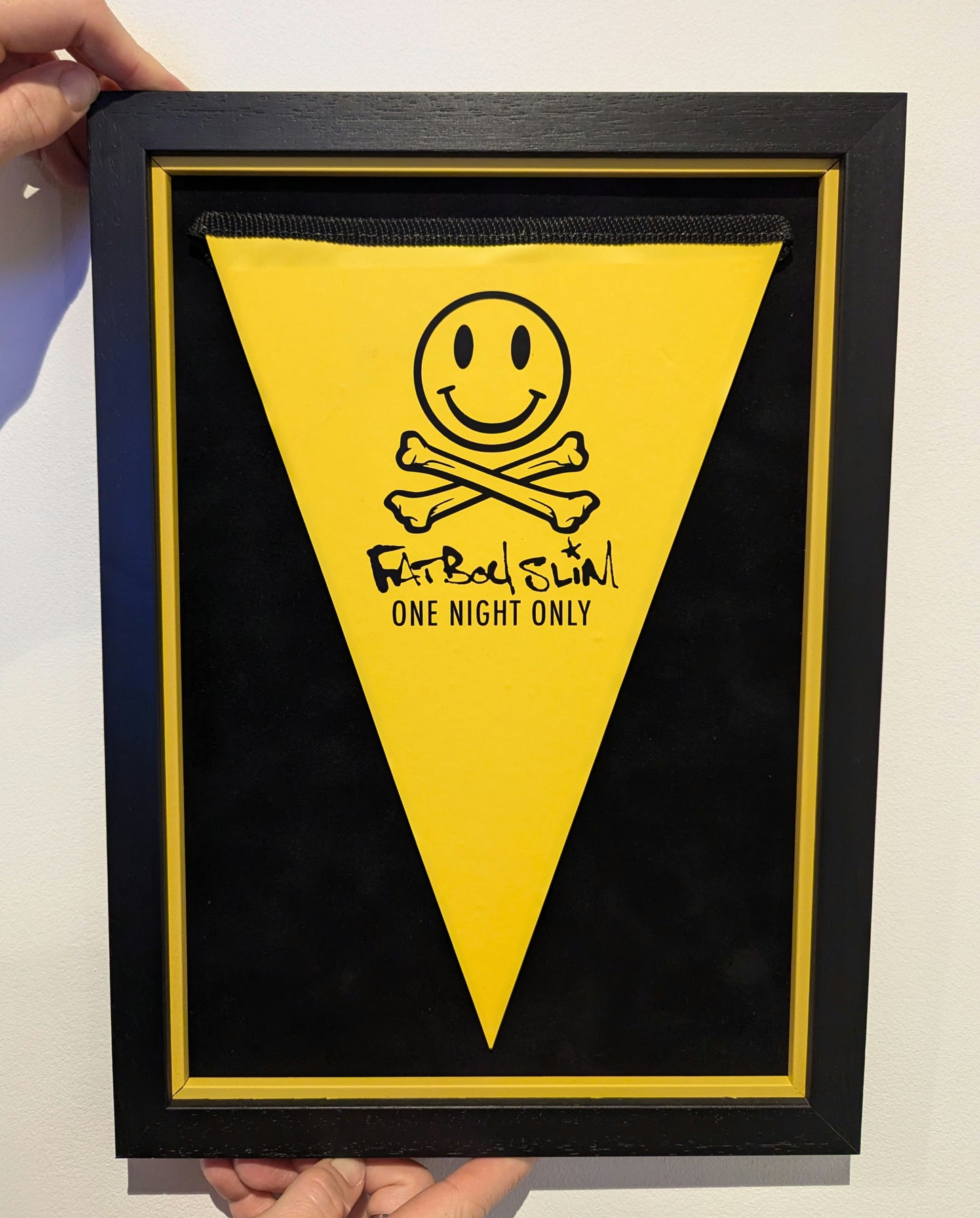 black and yellow frame with fatboy slim bunting, smiley face cross bones with text one night only.