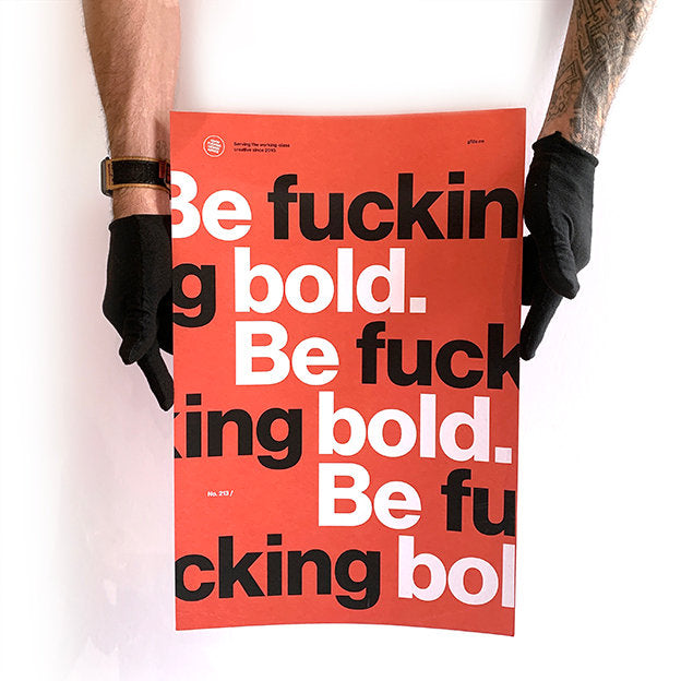 person wearing black gloves holding a red base colour print with be bold rude text