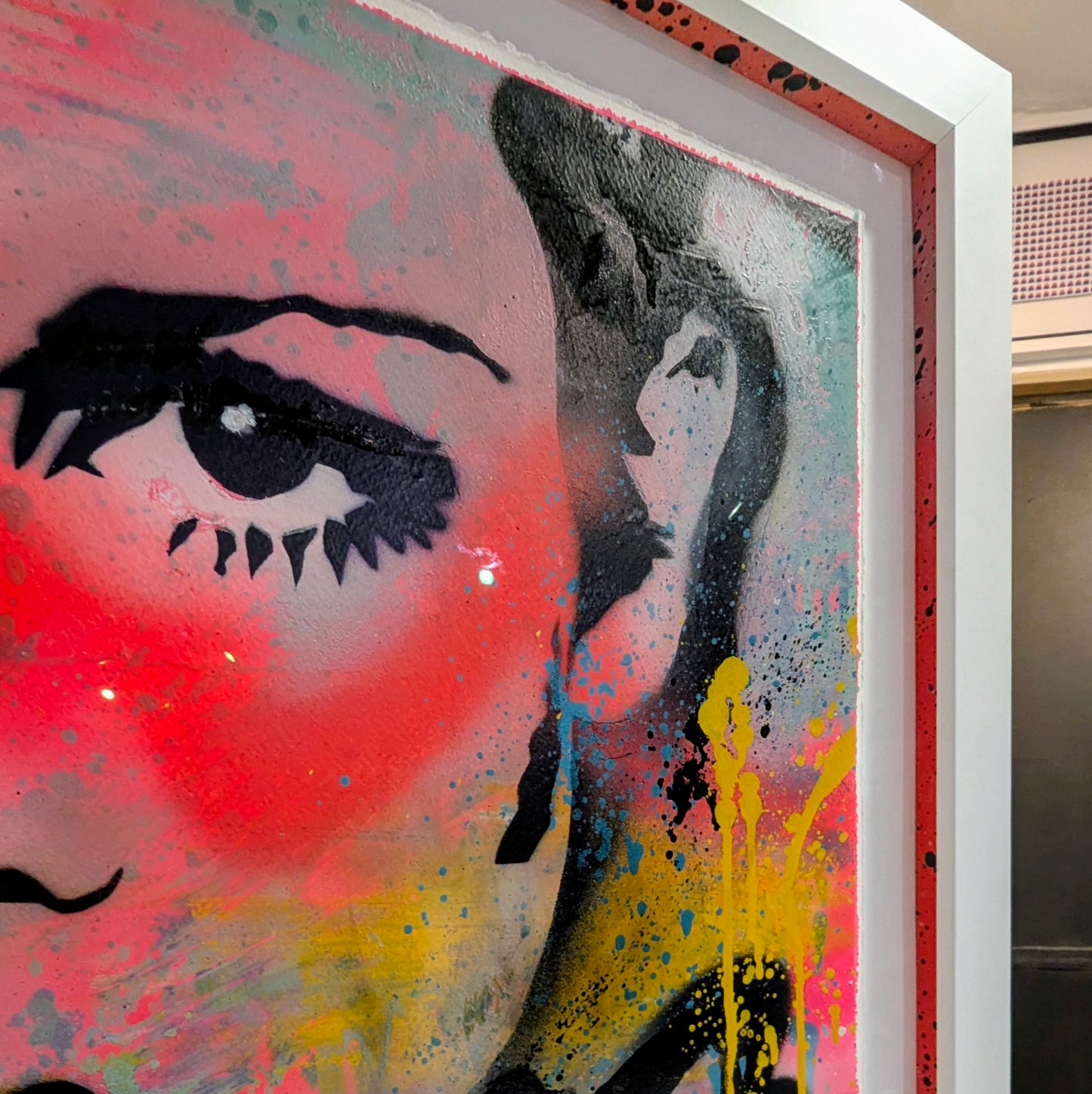 abstract bright colours of twiggys face framed in white frame, top right corner of frame with colourful slips