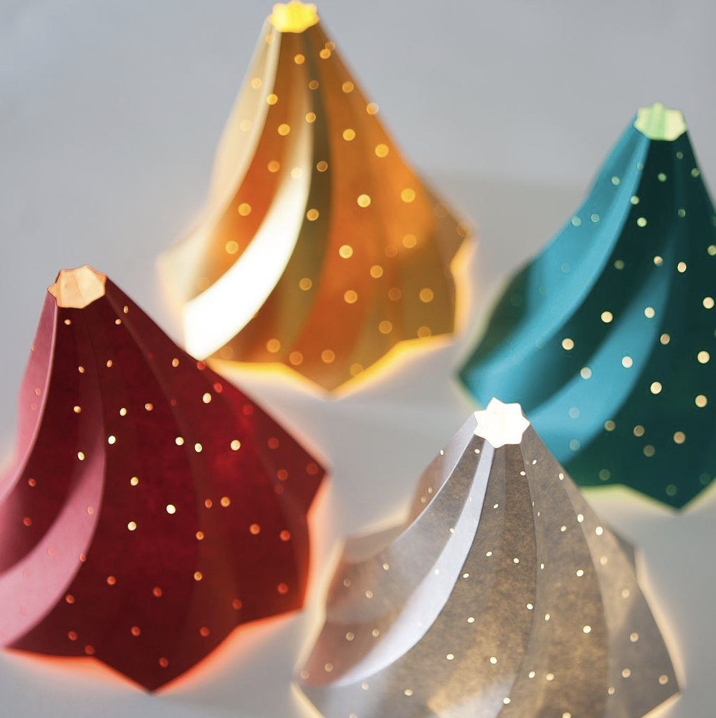 multiple colour Decorative Christmas tree paper sculpture with a star at the top on a grey background