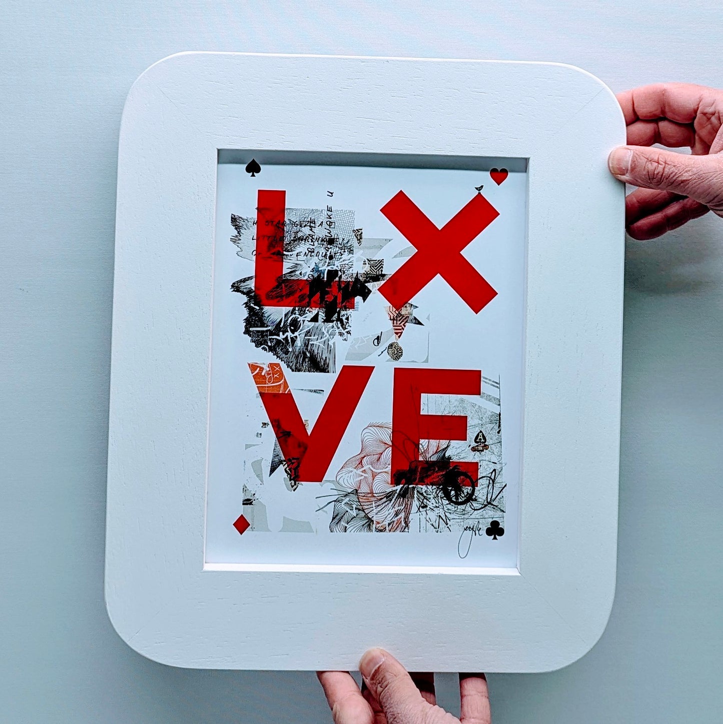 card game style love print, print is in a white picture frame with curved edges to replicate a playing card. frame is in fornt of a white background.