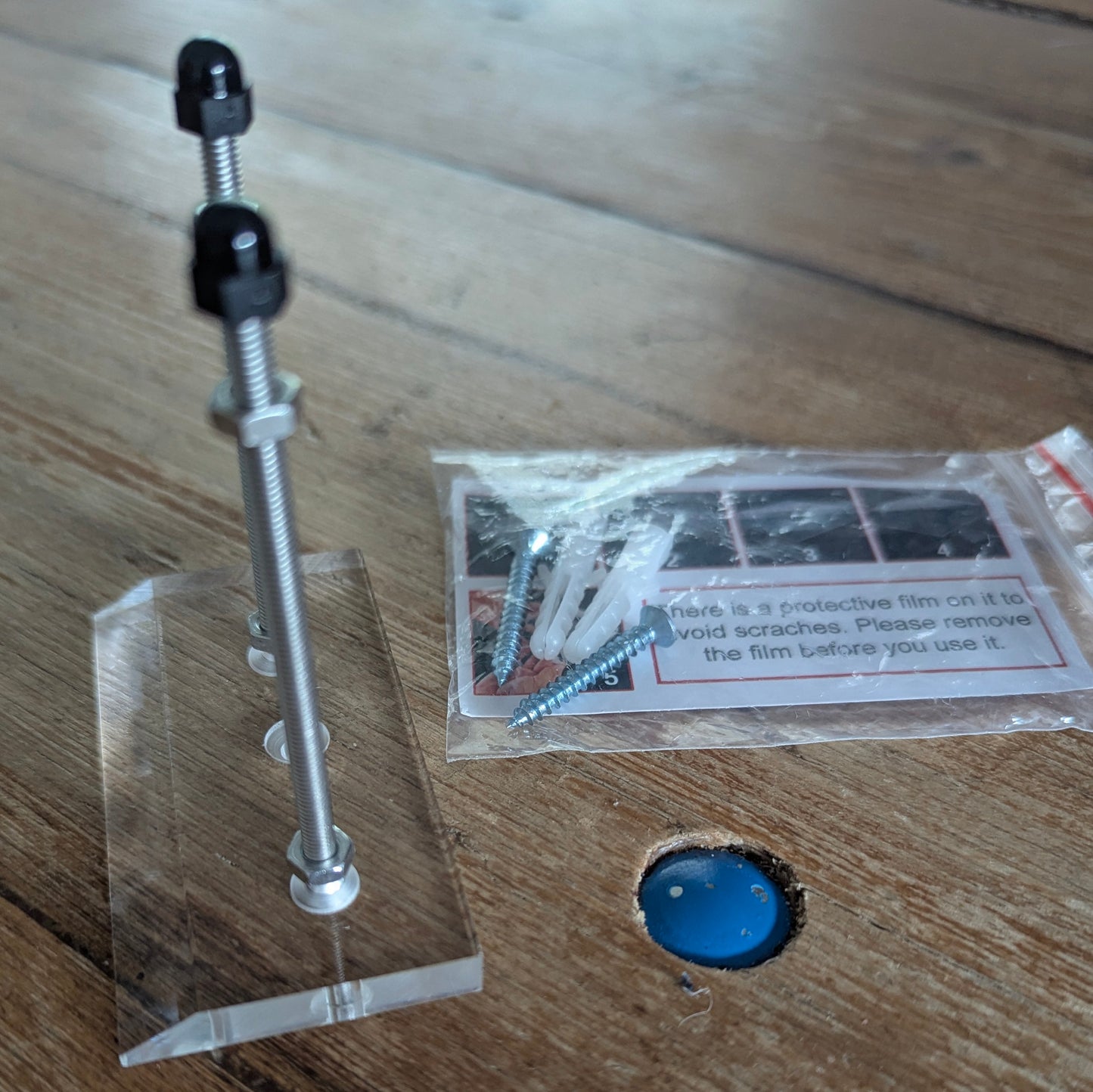 clear bracket for skateboard on wood background screws and bracket