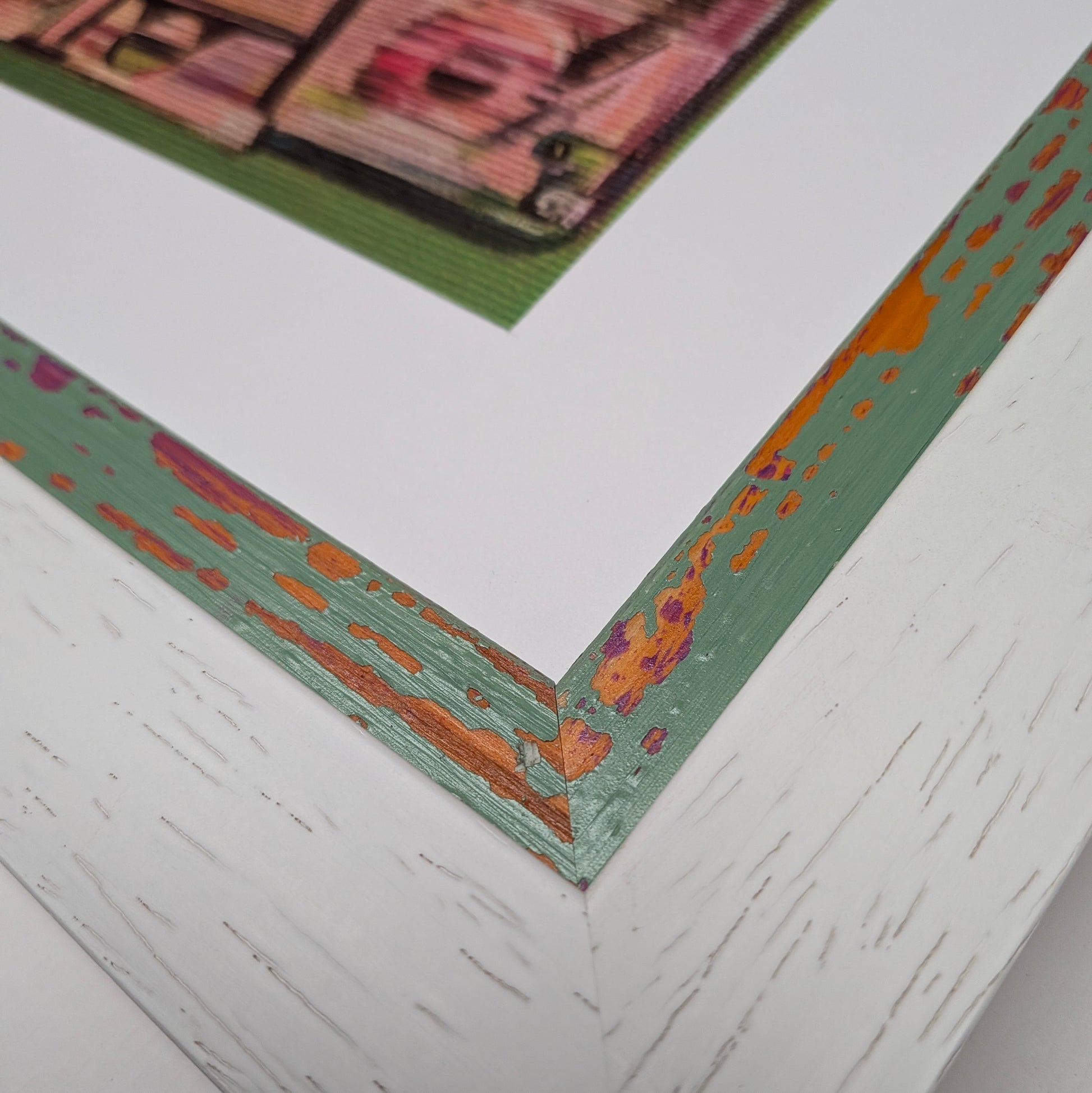 corner of white frame with colourful distressed interior frame, white mount for artwork