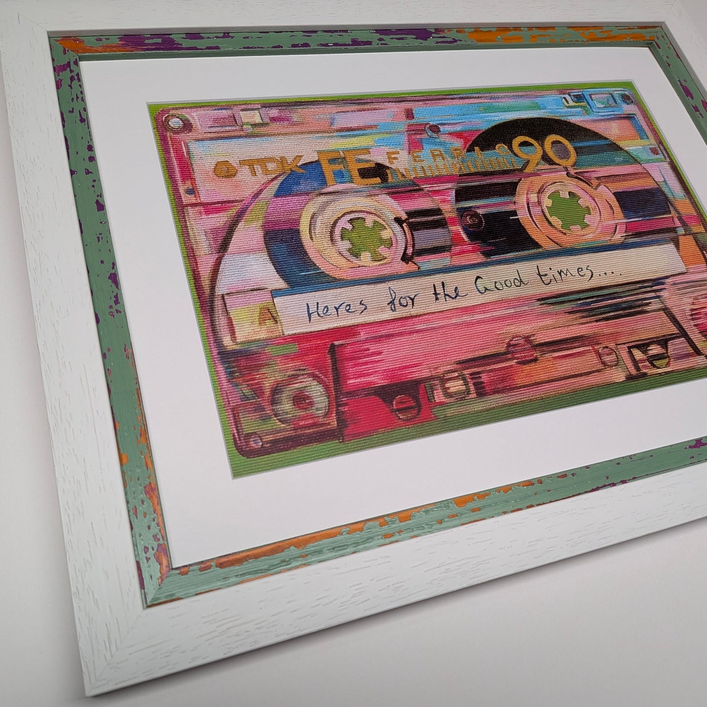 Framed wall art featuring a colourful collage of cassette tapes with the handwritten text 'Here's for the Good Times.