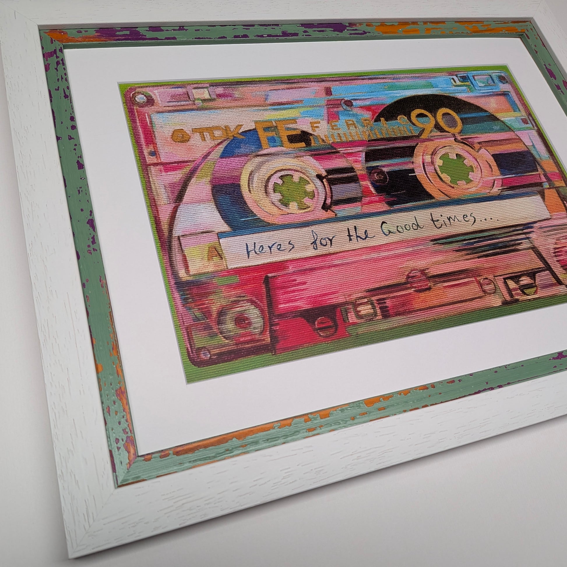 Framed wall art featuring a colourful collage of cassette tapes with the handwritten text 'Here's for the Good Times.