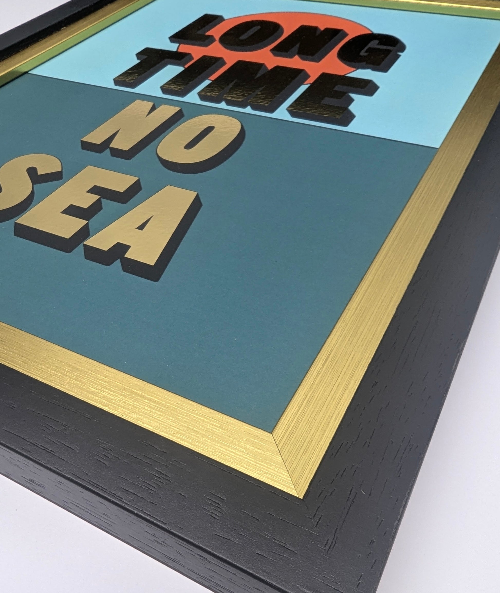 Framed artwork with text 'LONG TIME NO SEA' on a teal background