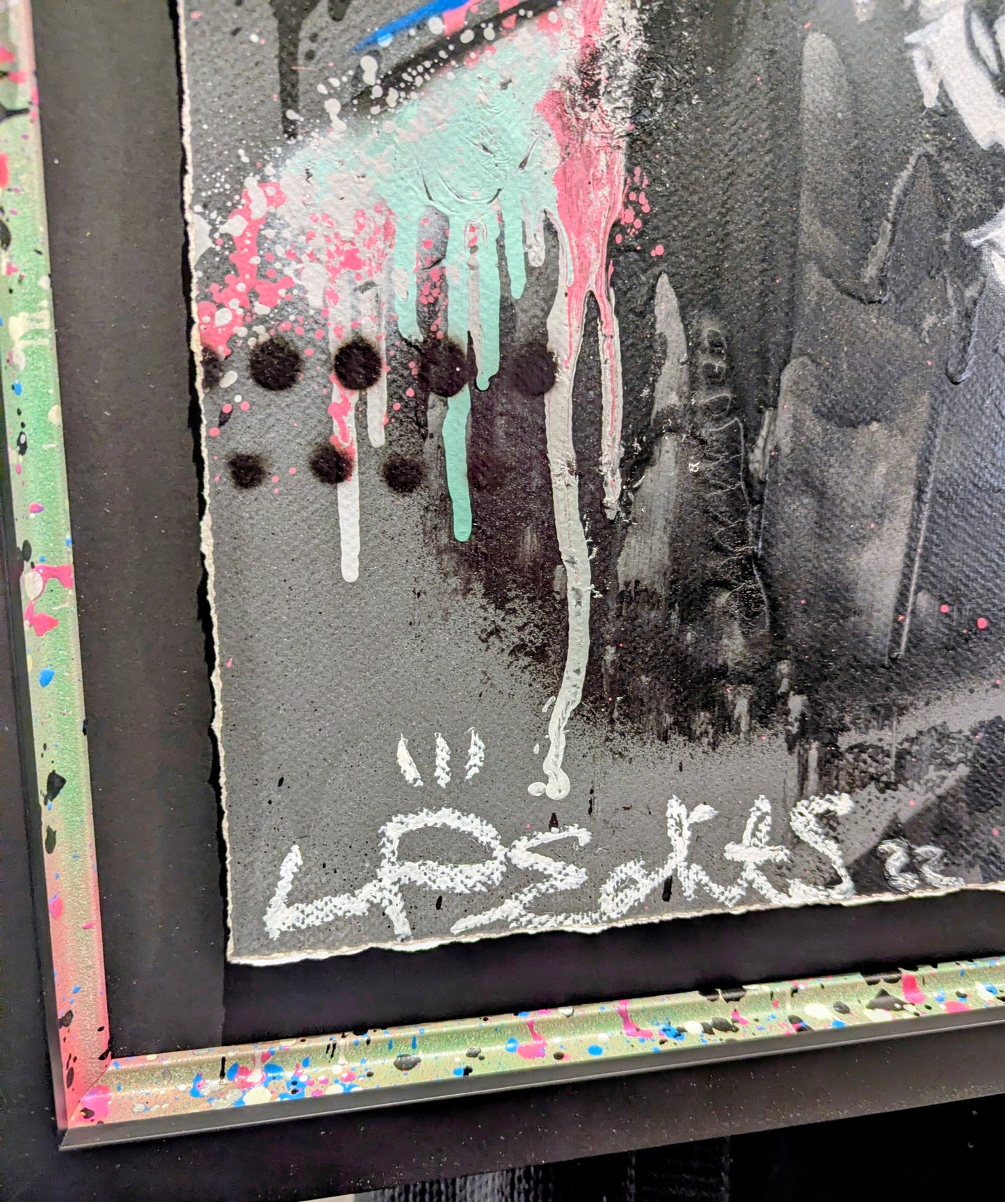 Artistic abstract piece with splashes of color and text on a black background