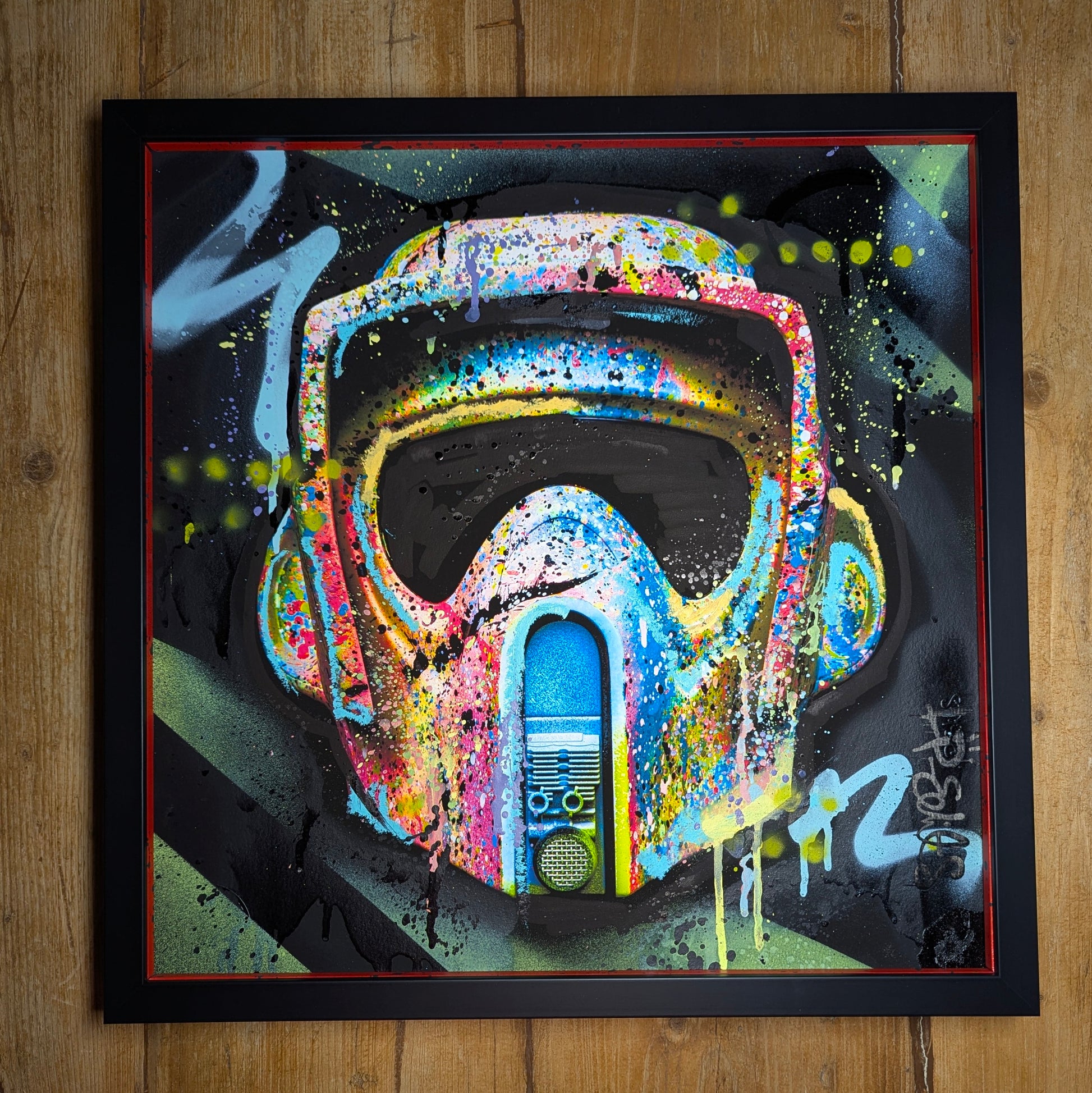 lp edits artwork print starwars style helmet, painted in a graffiti finish, print has then been hand embellished by lp edits, artwork has been framed in a black frame with silver slips that have been painted to match artwork.