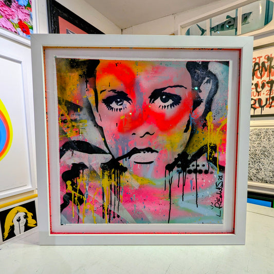 abstract bright colours of twiggys face framed in white frame in an gallery