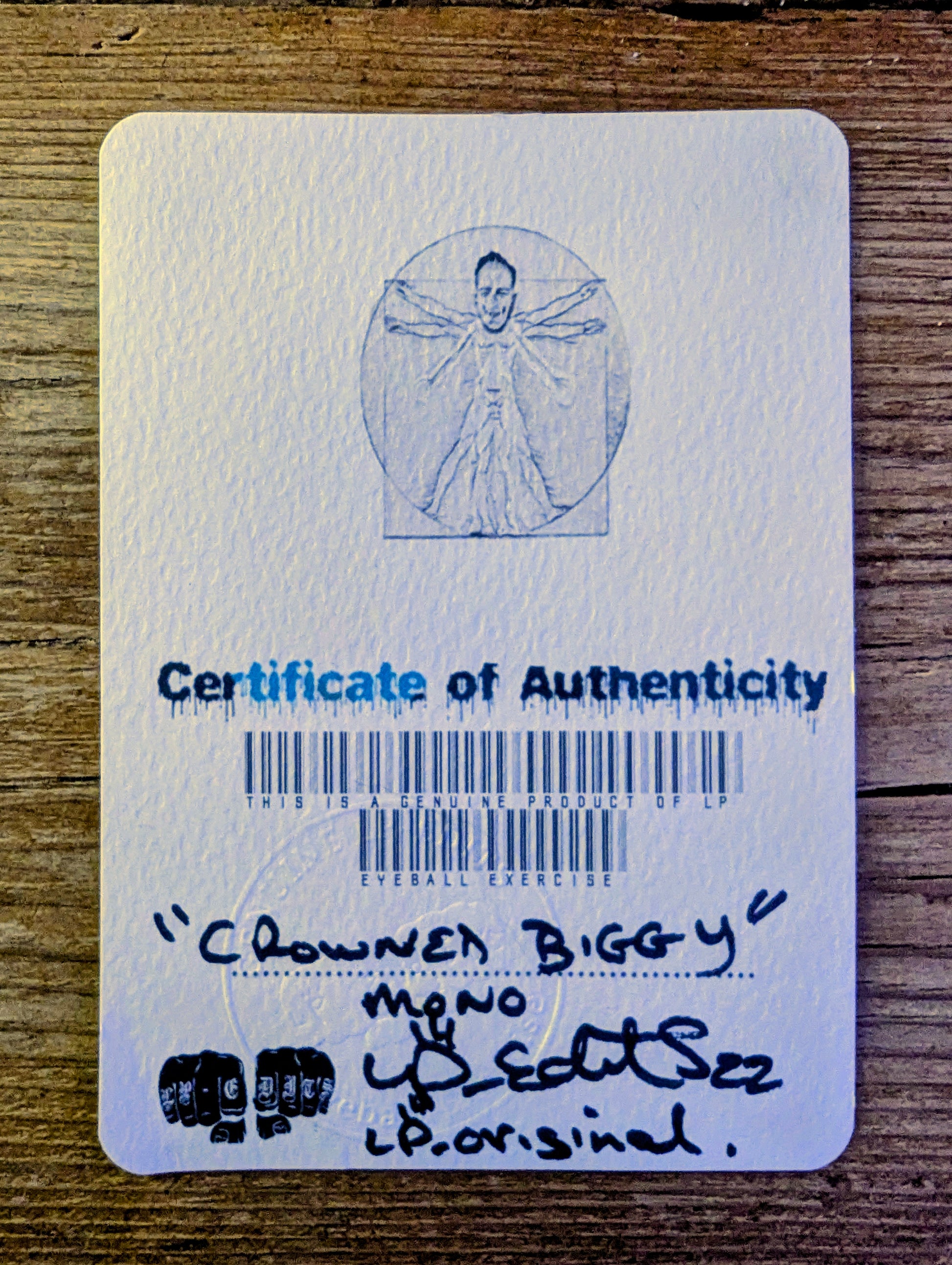 Certificate of Authenticity with a barcode and text on a wooden surface