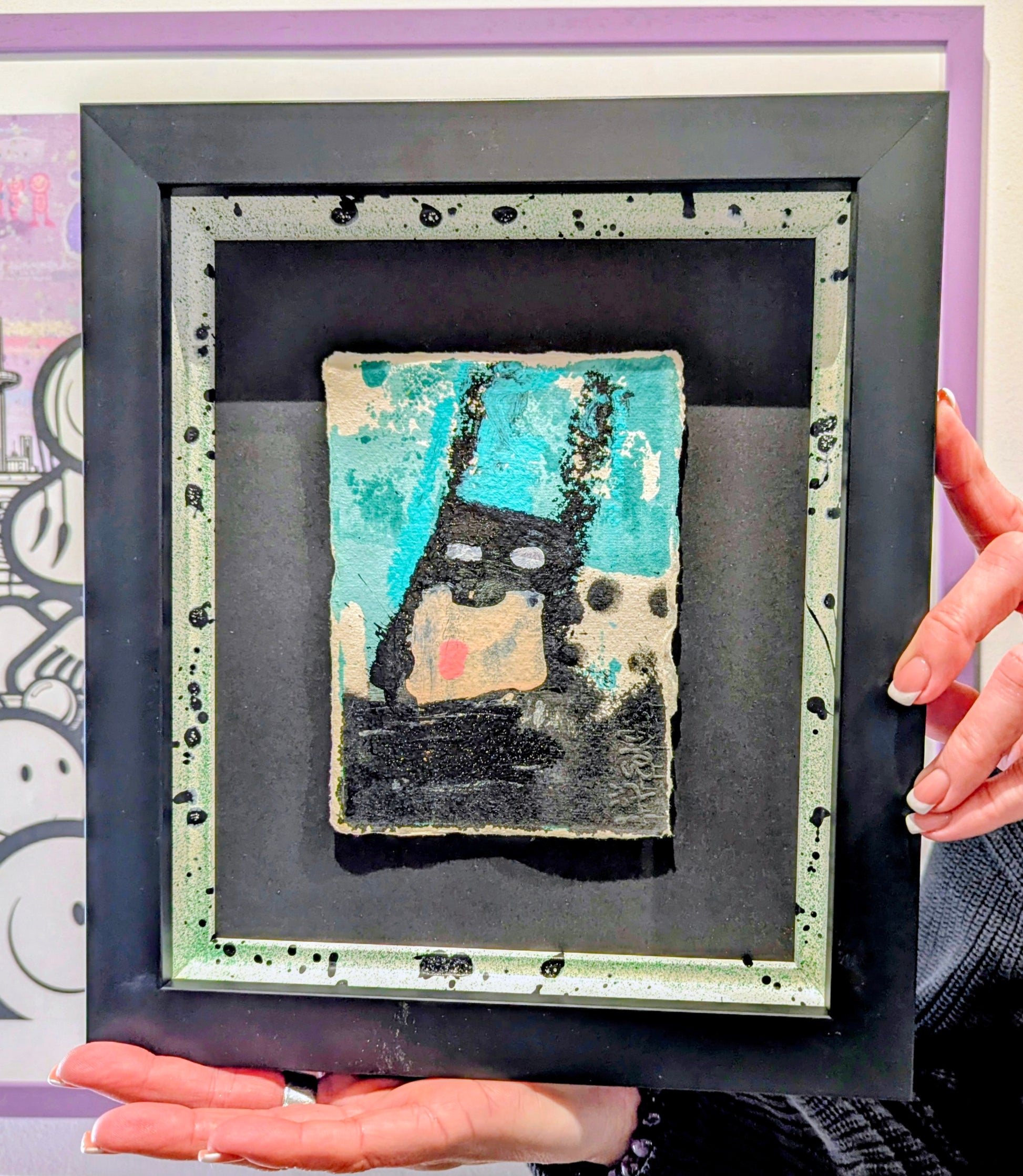 Framed abstract batman blue in bespoke frame, person holding it in front of other frames