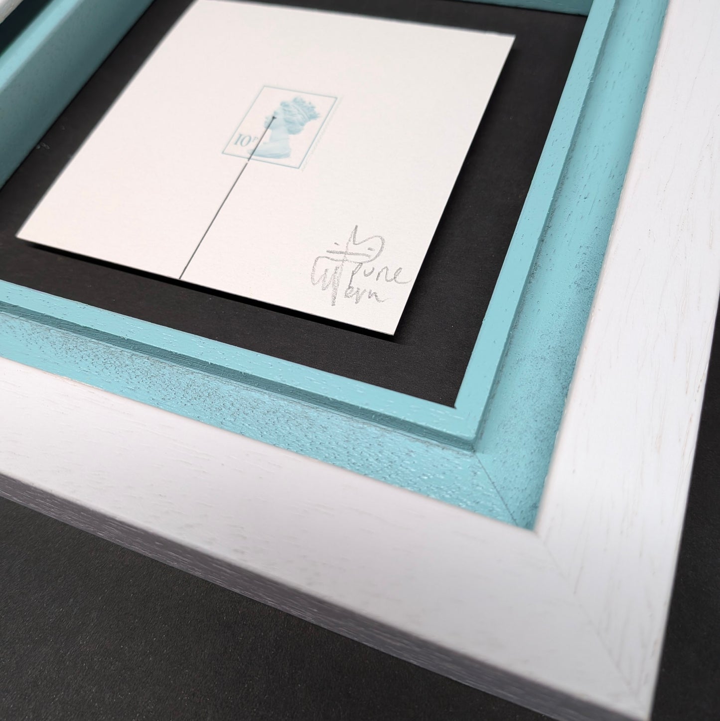 Framed artwork with a blue border and white mat