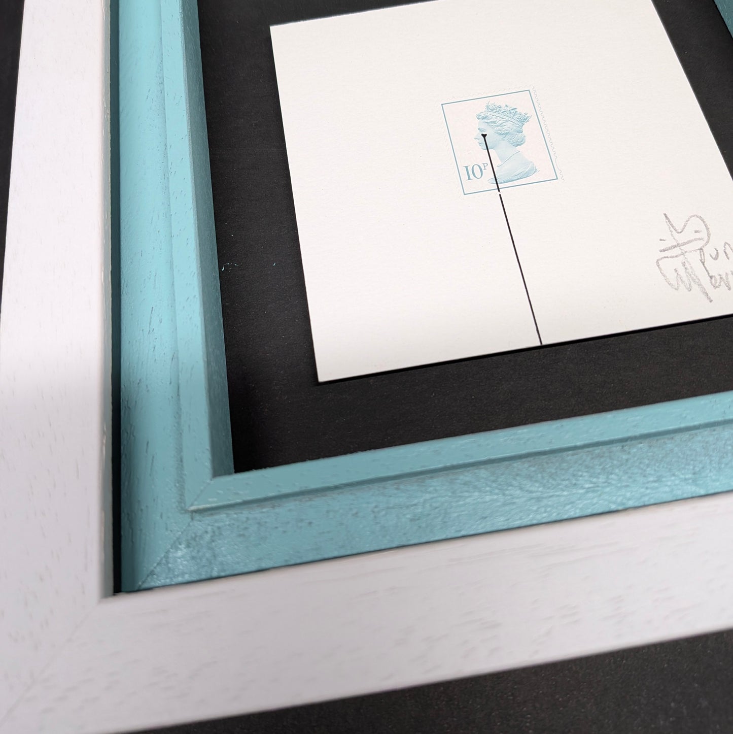 Framed artwork with a blue border on a white surface