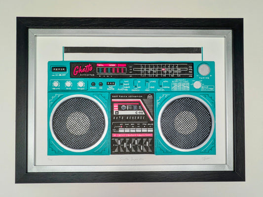 A framed art print depicting a retro boombox-style radio in bright turquoise and black, mounted on a light wall. The print is enclosed in a white mat and a thick black frame.
