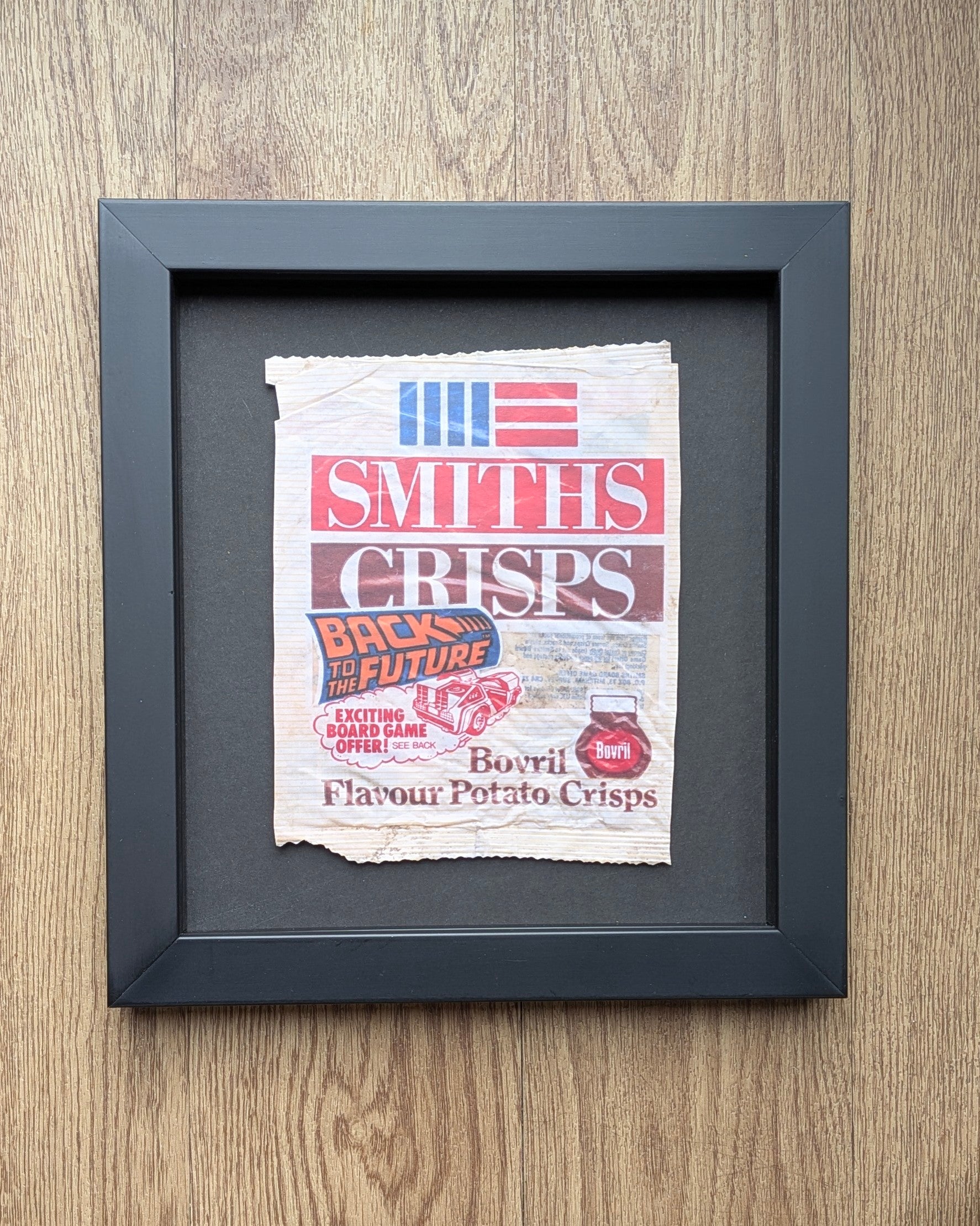 smiths bovril crisp print float mounted in black frame on a wood back ground