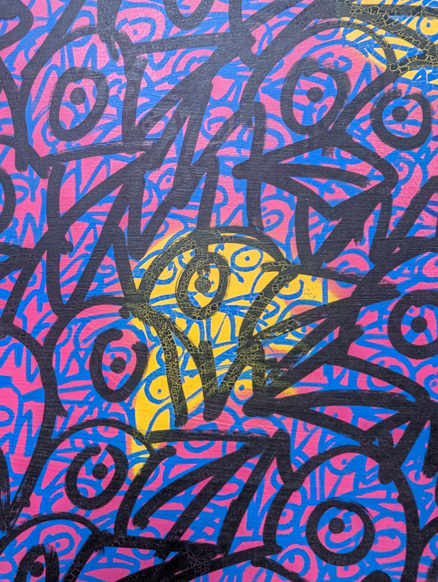 Colorful abstract pattern with black, blue, pink, and yellow colors on a textured background.