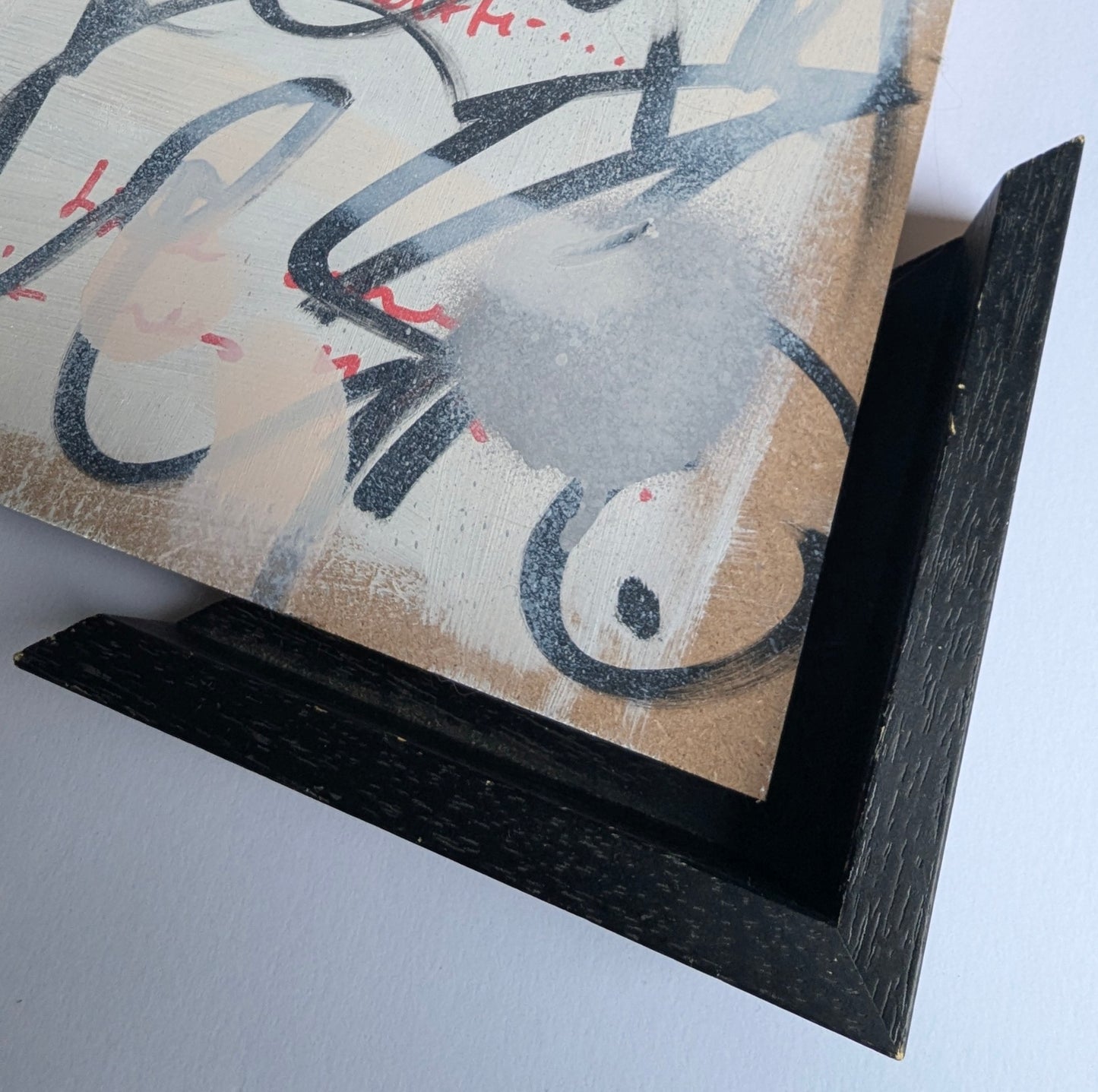 Black tray frame doodle artwork on white washed board 