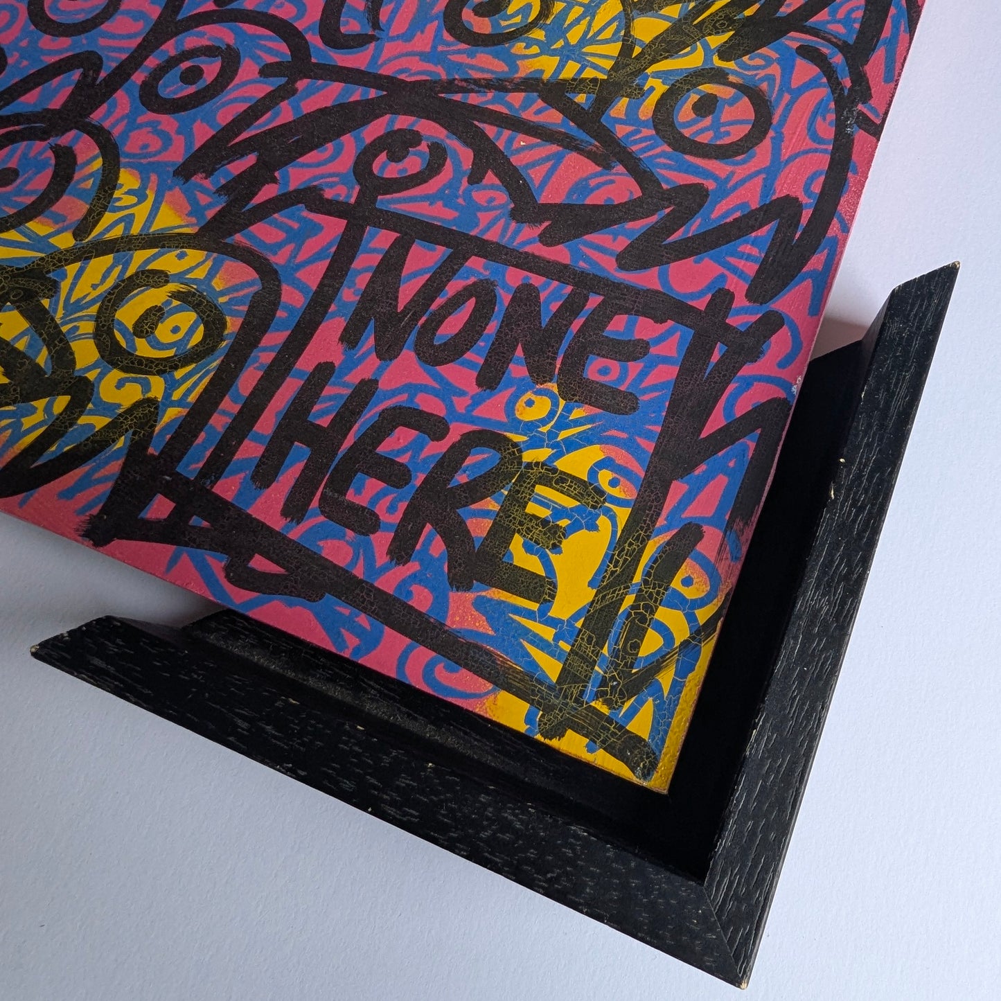 Colorful art piece bird graffiti heads next to tray frame