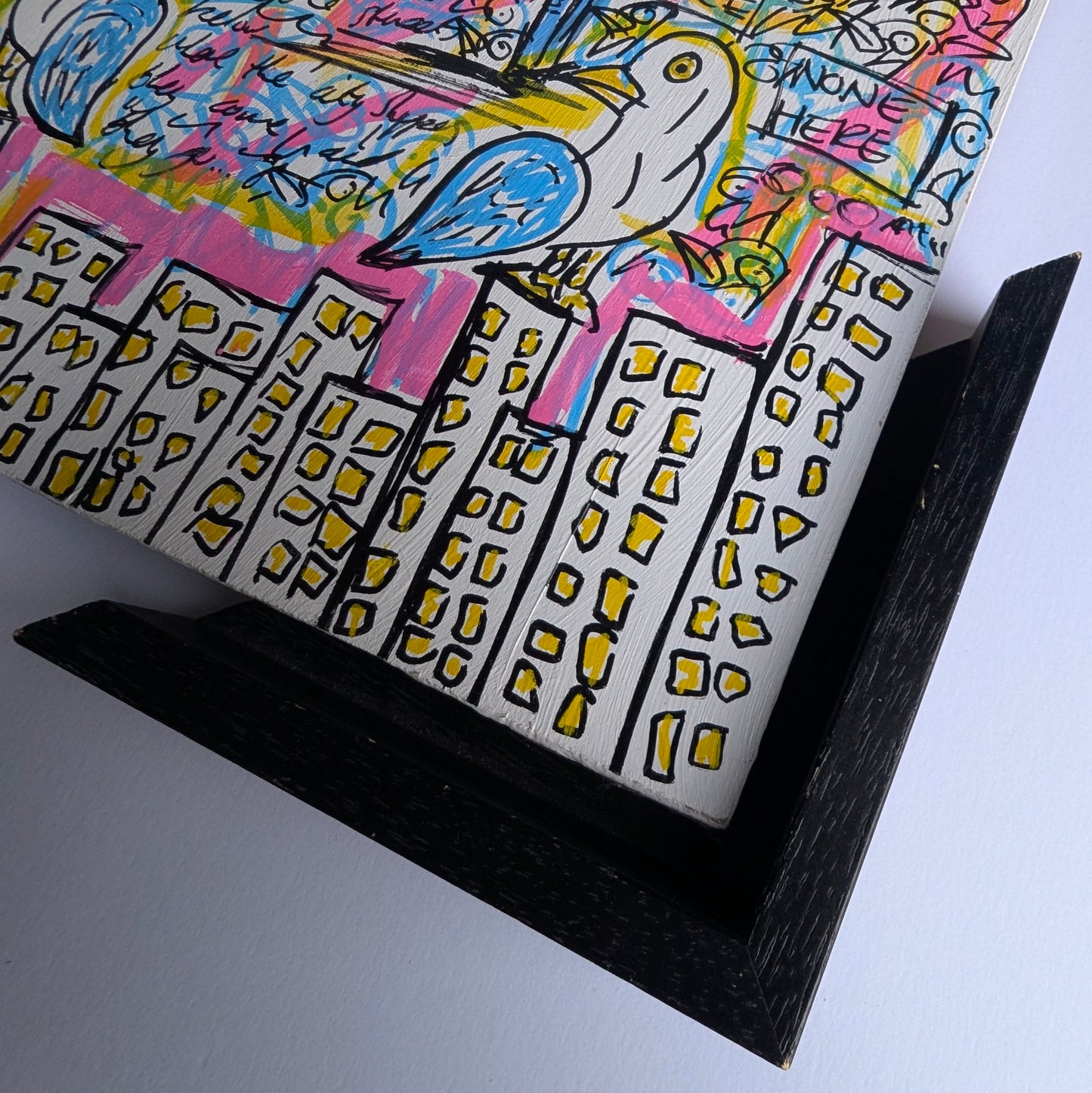 Colorful artwork with a bird and cityscape design on a white background