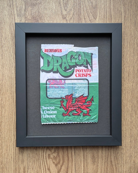 Framed picture of a vintage Bensons for Dragons potato crisps packet on a wooden surface