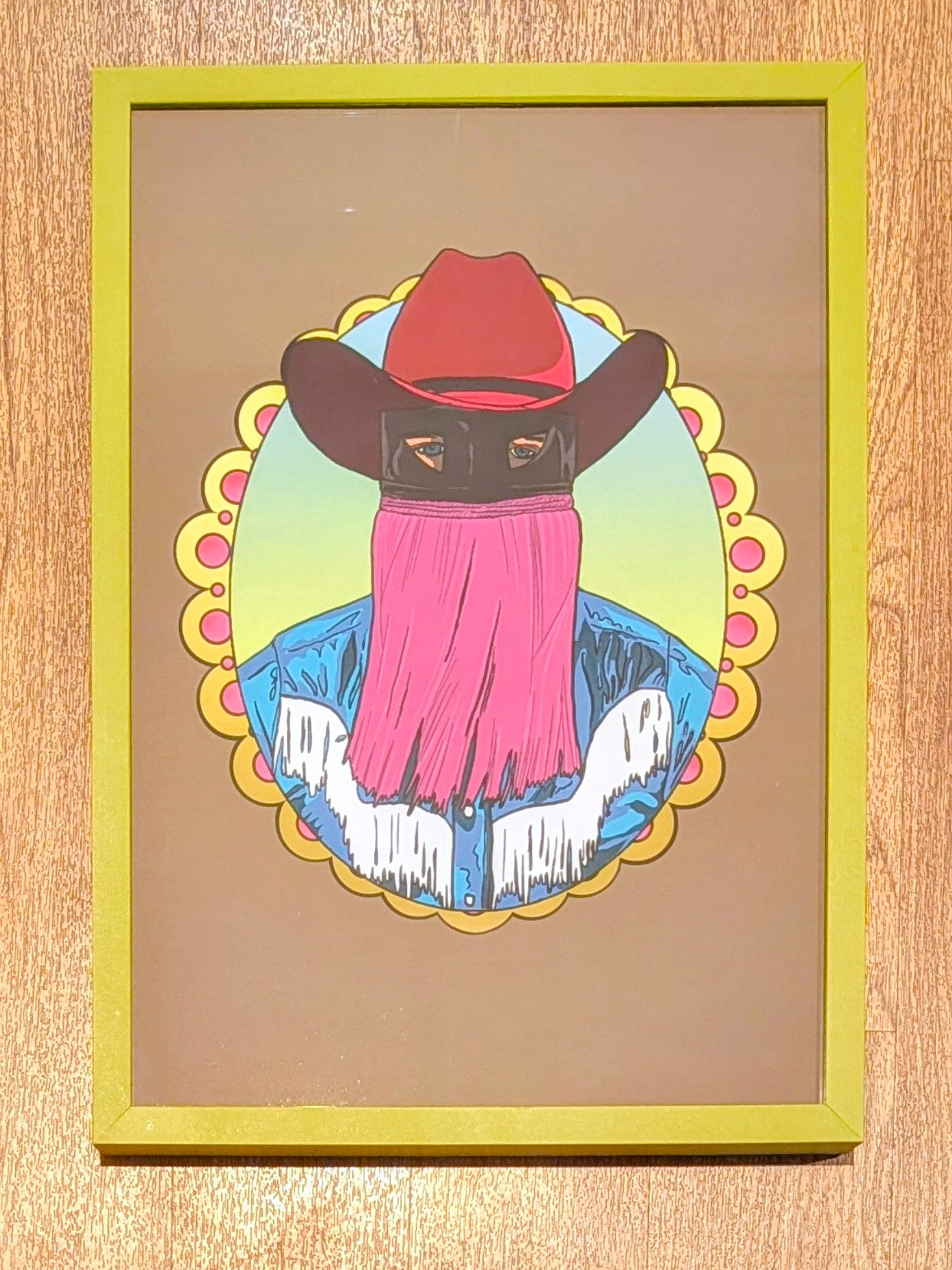 cowboy wearing a red hat and covered face in green picture frame