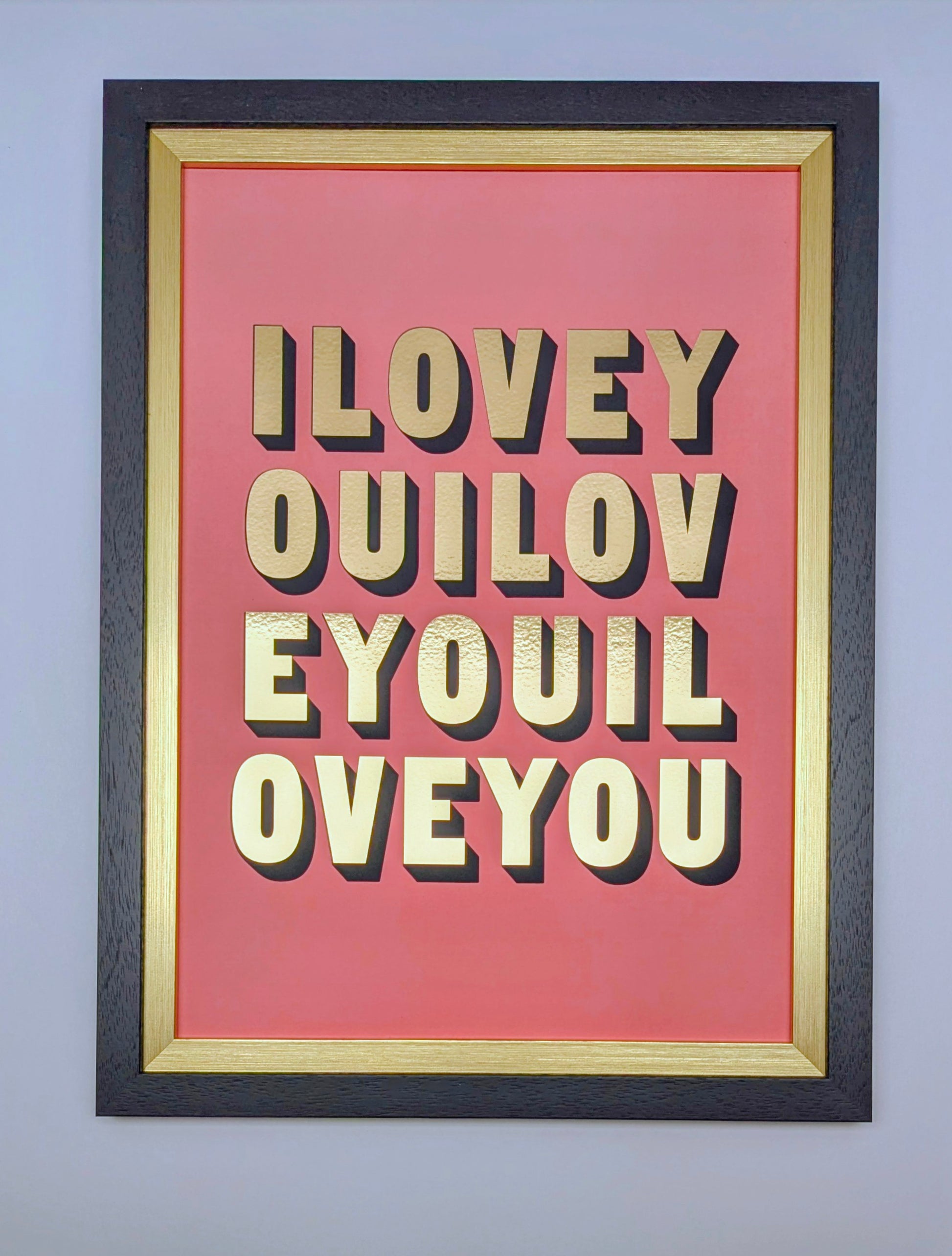 Framed artwork with 'ILOVEY OUILOV EYOUL OVEYOU' text on a pink background