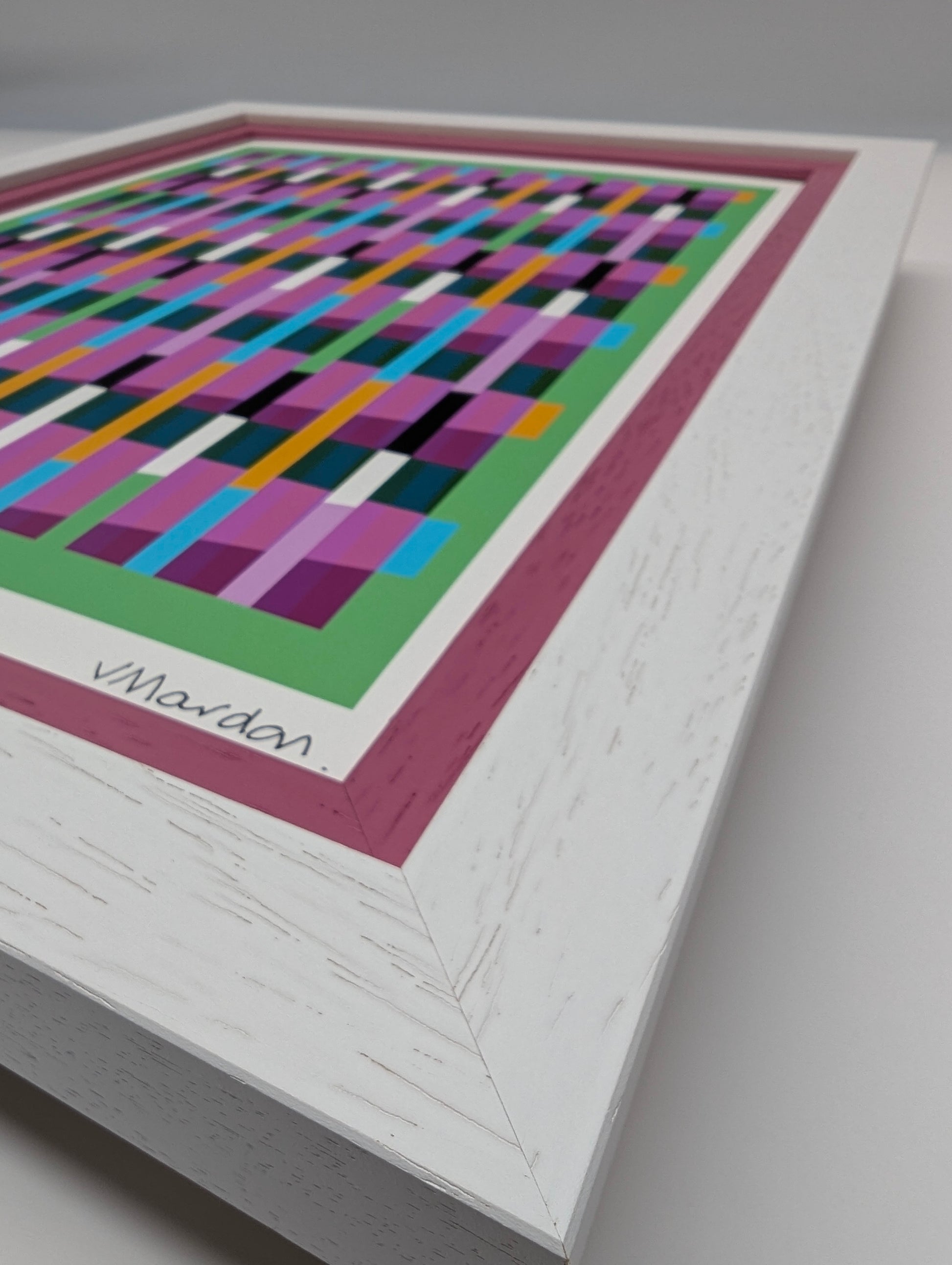 Framed abstract artwork with colorful geometric design on a gray background