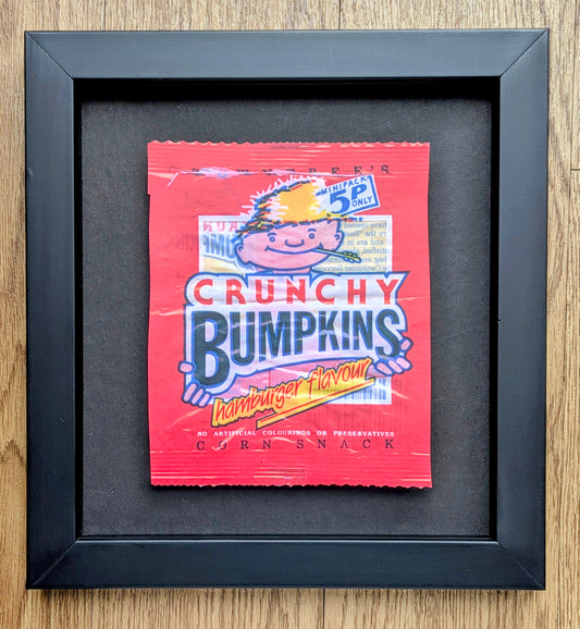 Framed poster of a Crunchy Bumpkins corn snack packet on a wooden surface