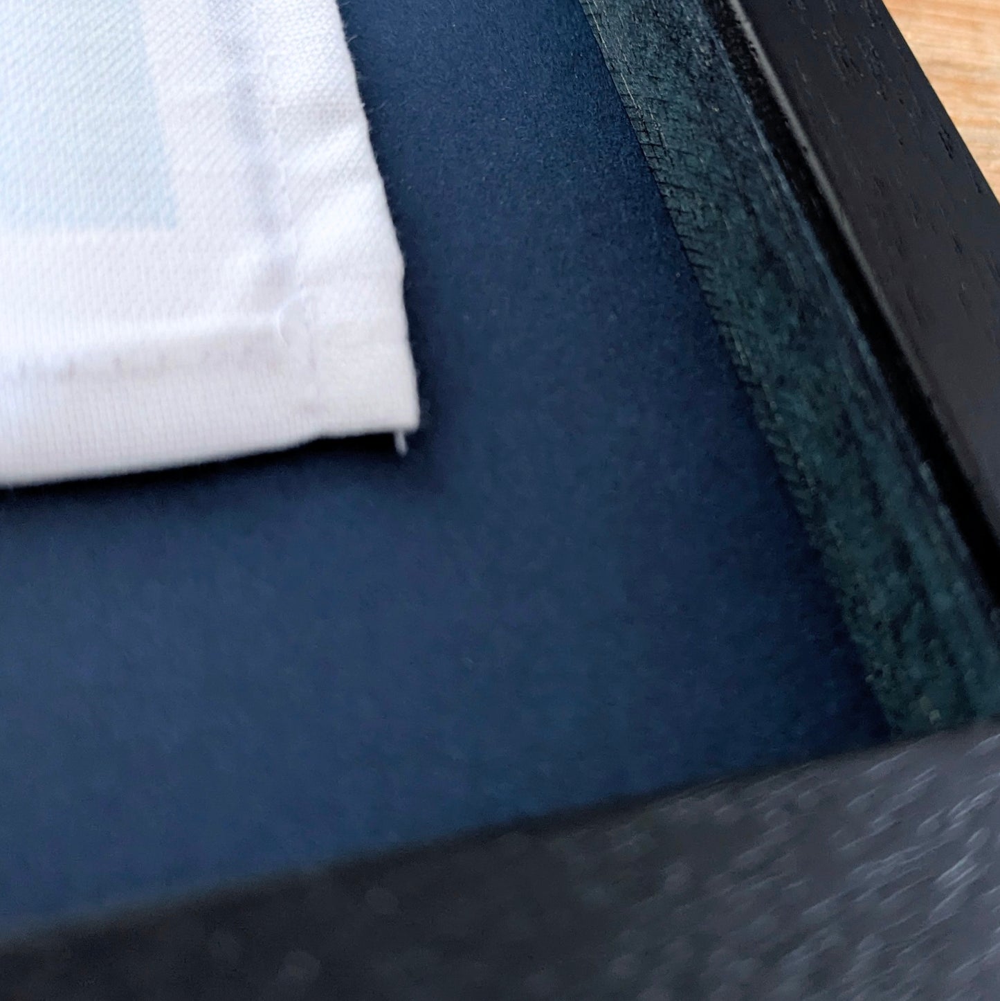 Close-up of a textured fabric surface and corner of the frame