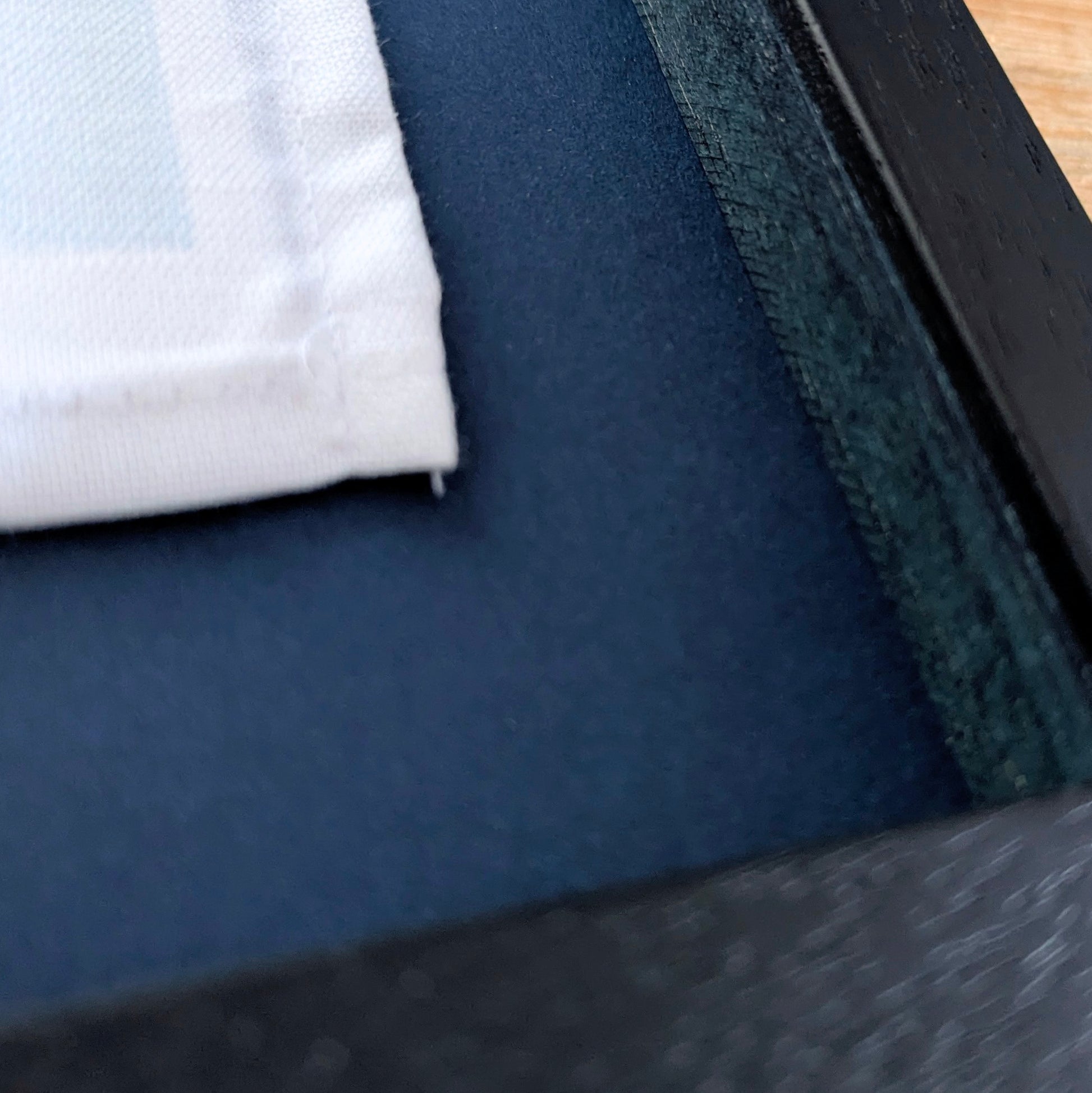 Close-up of a textured fabric surface and corner of the frame
