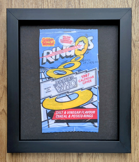 Framed RINGS 80s Doctor Who cereal box on a wooden surface