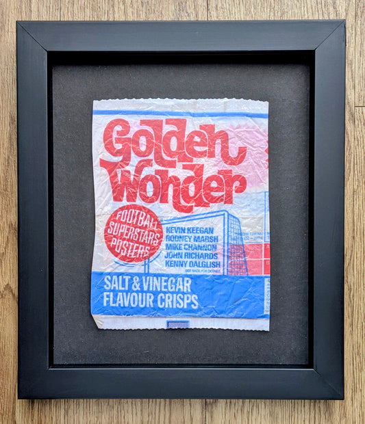Framed Golden Wonder crisp packet on a wooden surface