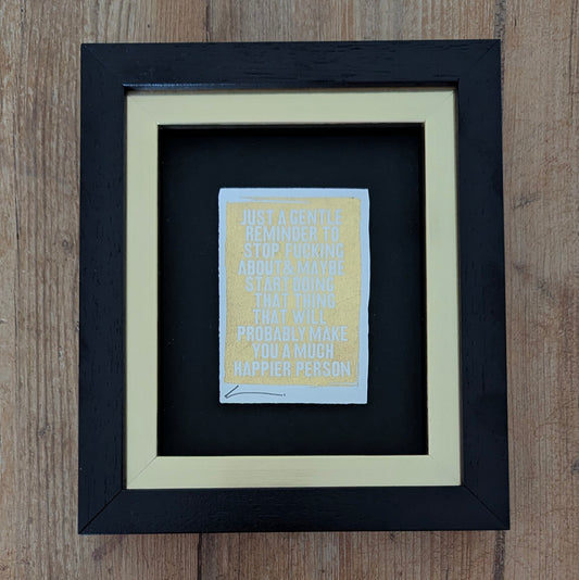 Framed Hackney Dave print with motivational quote printed with gold leaf on a wooden surface
