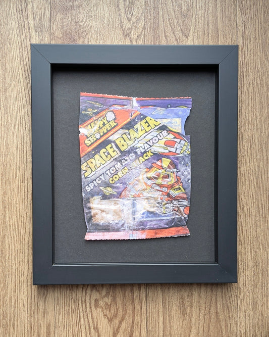 Framed vintage happy shopper crisp wrapper on a wooden surfaces