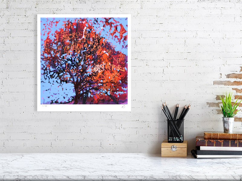 Framed abstract artwork of a tree with red leaves on a white brick wall.