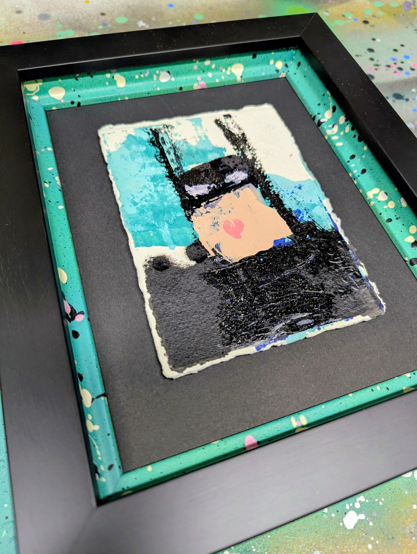 Framed batman artwork with a colourful abstract design on a black background