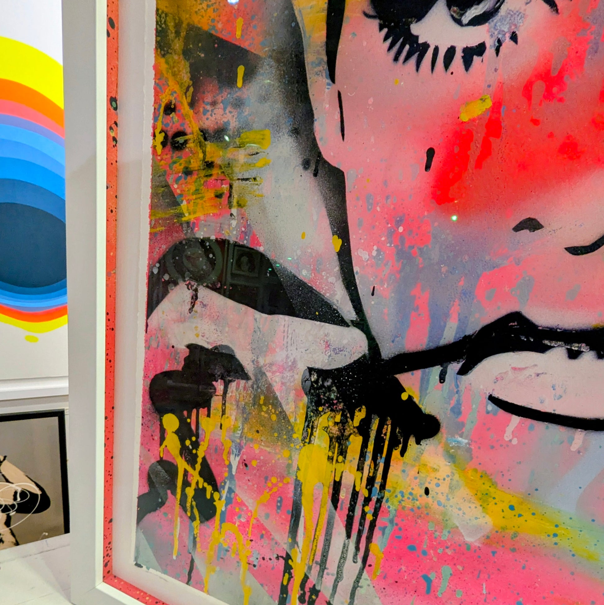 abstract bright colours of twiggys face framed in white frame, bottom left corner of frame with colourful slips