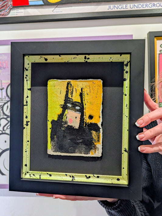Framed abstract batman in bespoke frame, person holding it in front of other frames