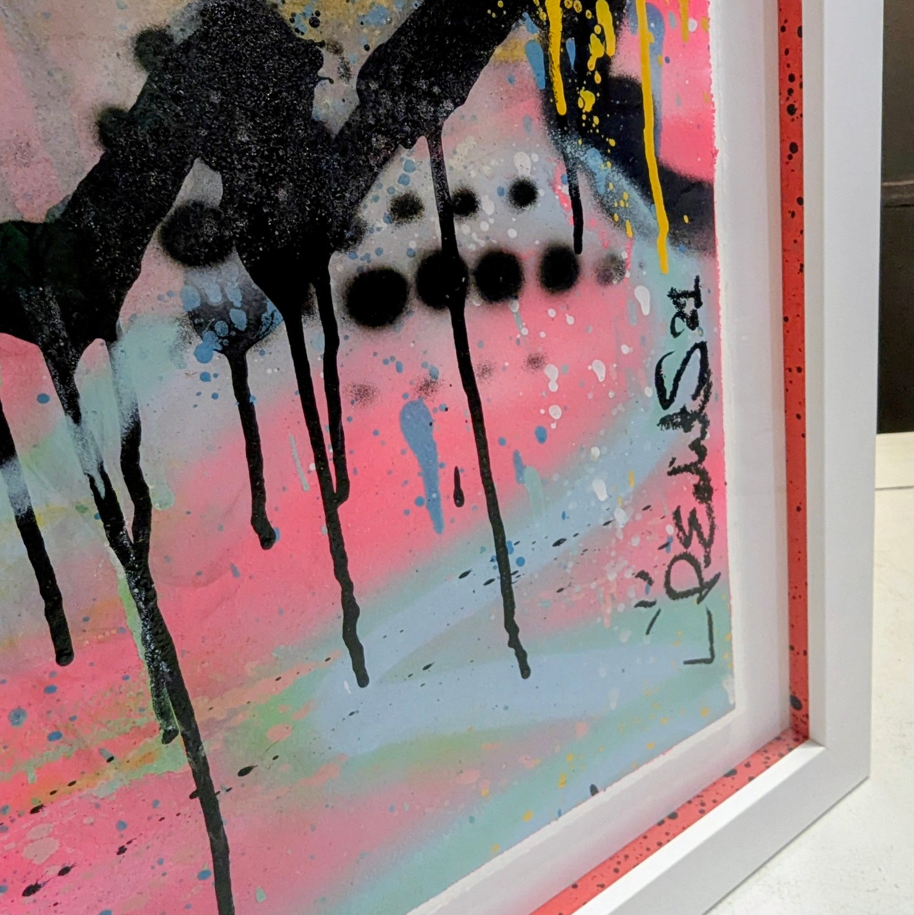 abstract bright colours of twiggys face framed in white frame, bottom right corner of frame with colourful slips