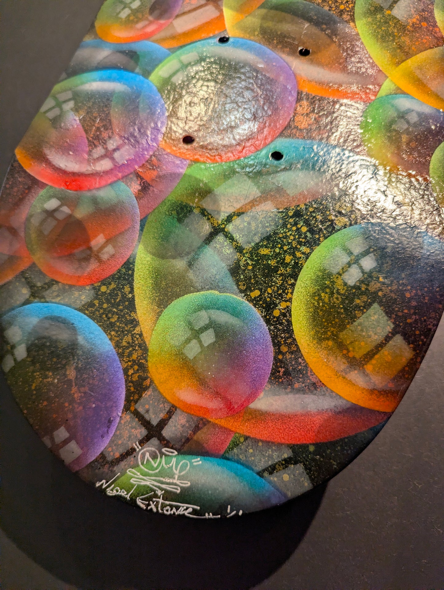 Colorful abstract art with a signature on a dark background