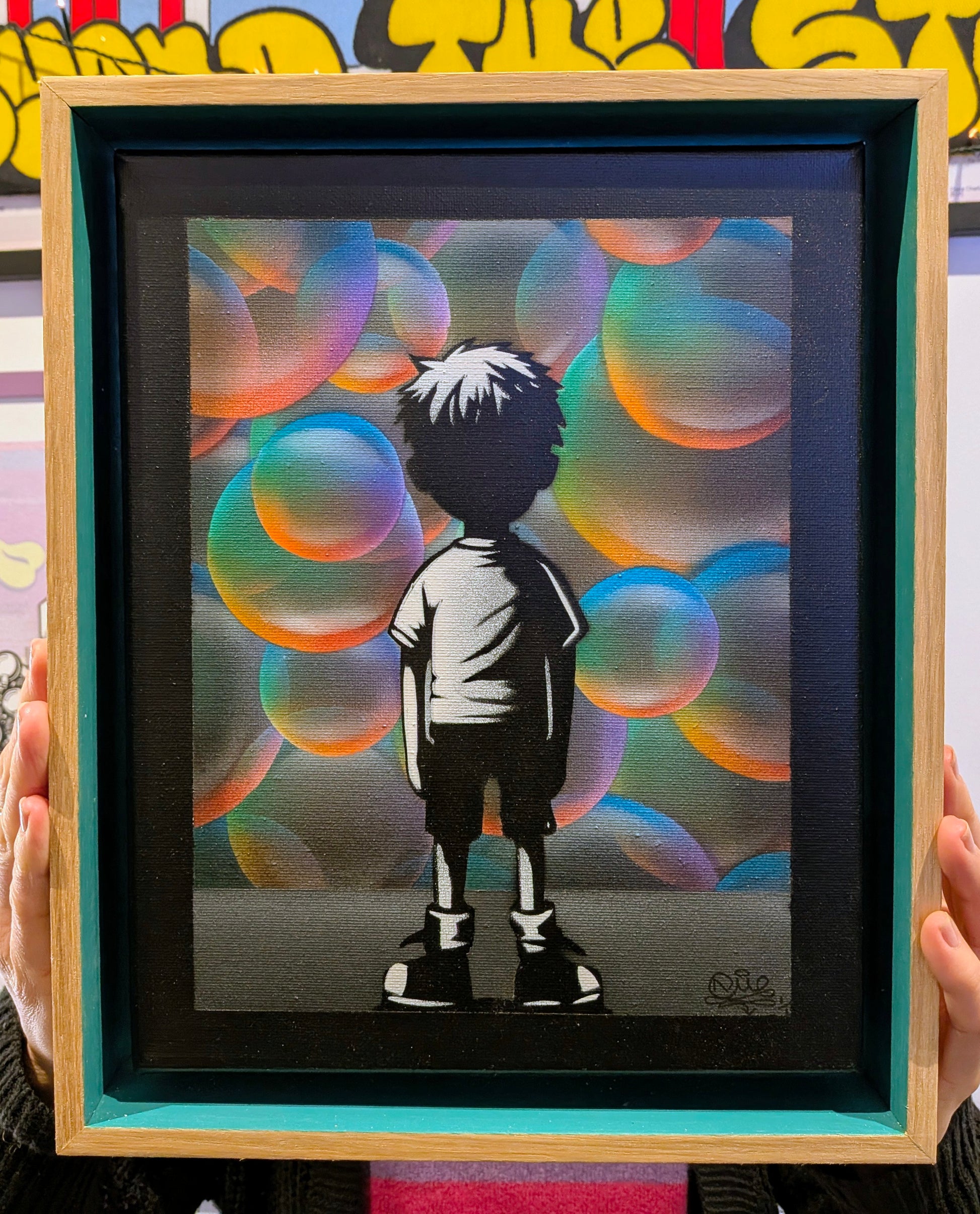 Framed artwork of a silhouette of a child against colorful bubbles