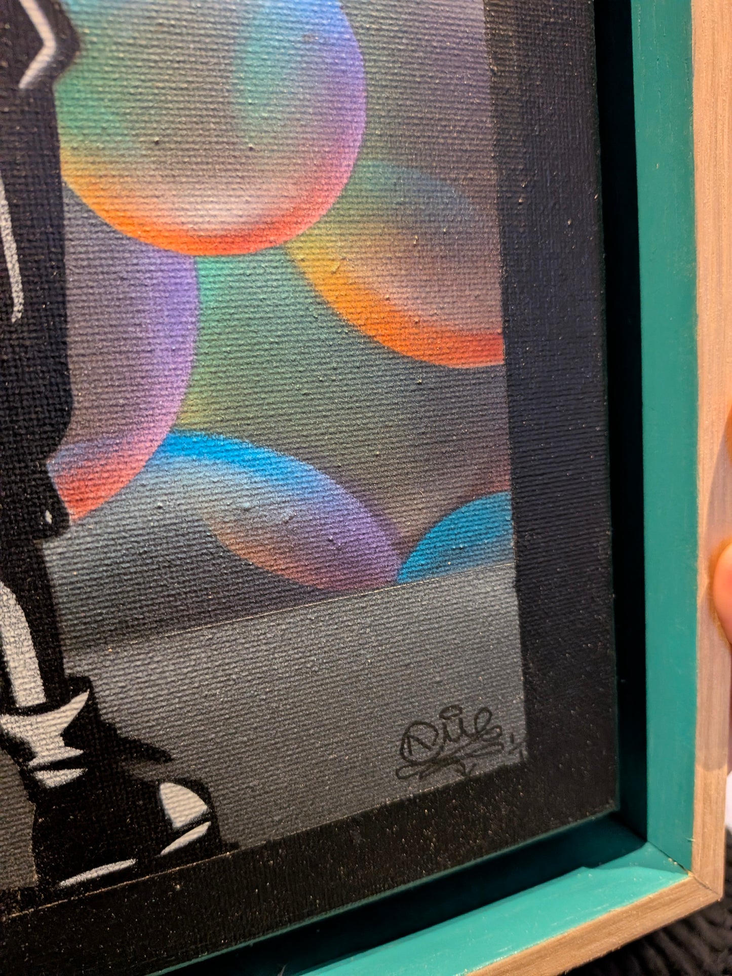 Framed artwork with colorful abstract design and signature at bottom right corner.